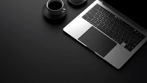 Minimalist laptop workspace with coffee on dark desk.