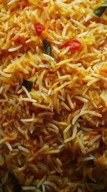 Close-up view of spiced rice with vegetables and herbs.