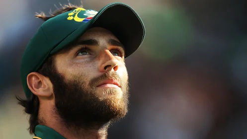 Cricket player close-up in golden sidelight, contemplative gaze.