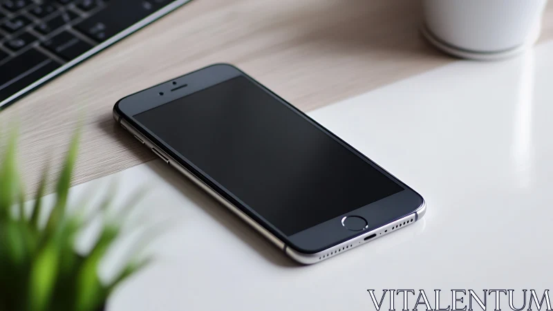 Smartphone on wooden desk with workspace peripherals