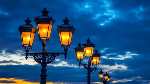 Row of illuminated street lanterns against dusk sky.
