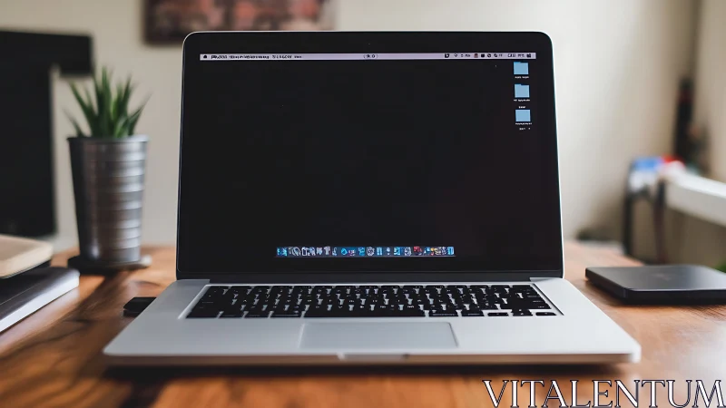 Laptop computer is positioned centrally on wooden desk surface