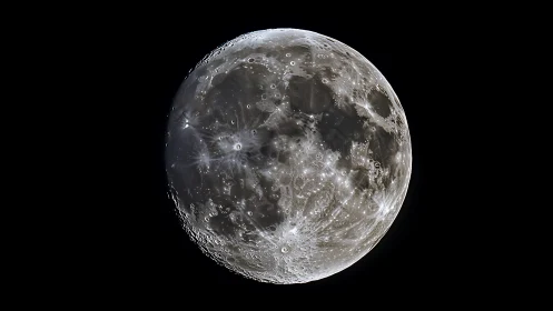 High-contrast lunar close-up with crater-rich surface detailing.