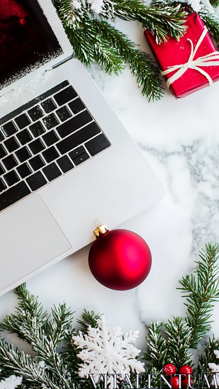 Laptop workspace with red Christmas ornament and gift