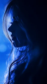 Side profile silhouette in deep blue studio lighting.