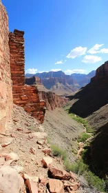 Desert canyon escarpment with eroded stone wall and green wash