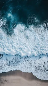Foaming ocean waves crash onto a tranquil sandy shoreline