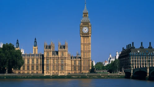 Clock tower and parliamentary complex beside urban river.