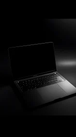 Open laptop computer on dark reflective studio surface.