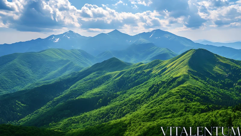 Sunlit green mountain ridges under distant blue peaks.
