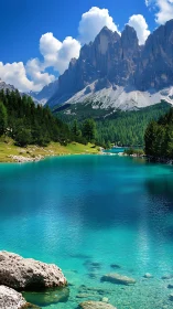 Turquoise alpine lake below towering rocky mountain peaks.