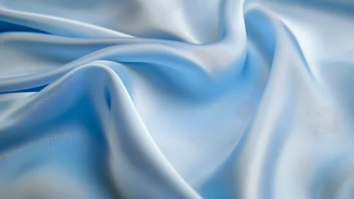 Smooth pale blue satin fabric forms soft specular wave folds