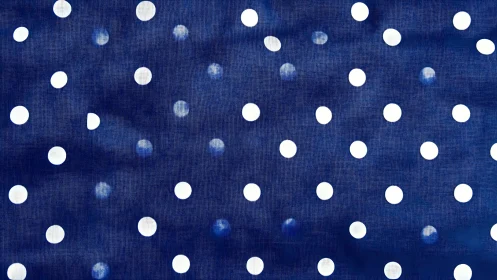 Bold white polka dots punctuate textured navy fabric pattern.