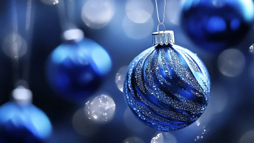 Blue glass ornament glows amid soft holiday bokeh lights.