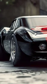 Rear three-quarter detail of black classic sports coupe.