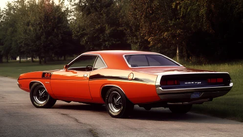 Classic orange muscle car is parked on a quiet tree-lined road