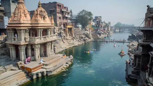 Riverfront temple ghats with bathers in hazy daylight scene.