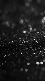 Glittering black surface photographed with strong bokeh blur