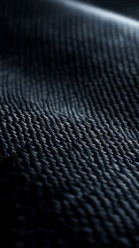 Surface close-up shows dark woven texture under raking light