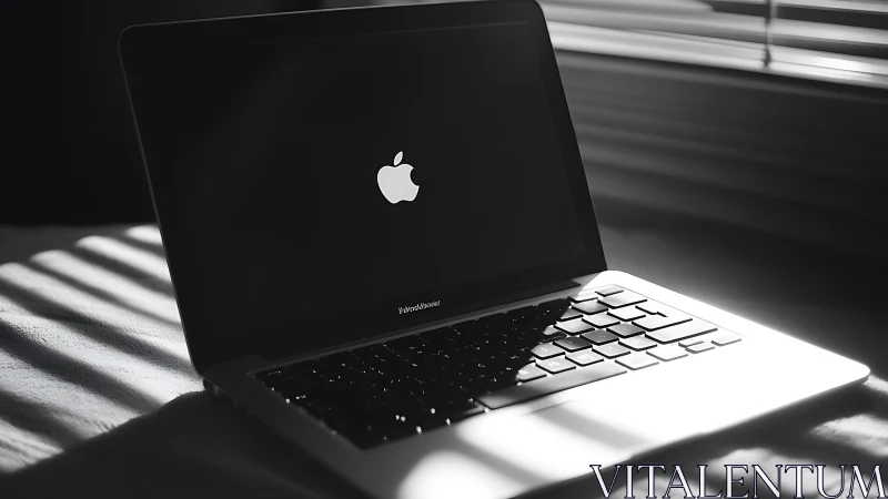 Closed laptop on bed with strong window light pattern.