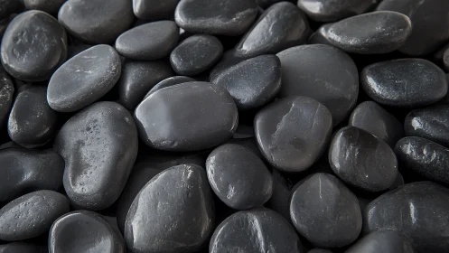 Close-up macro view of smooth wet black basalt river pebbles