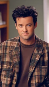Soft-lit portrait of young man in plaid flannel jacket, studio