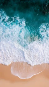 Crashing ocean waves wash gently over soft sandy shoreline.