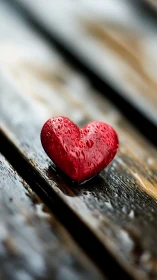 Red Heart Wet with Water Droplets on Wooden Surface