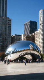Reflective urban sculpture anchors plaza amid tall buildings
