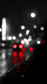 Rain soaked city rail reflects red bokeh night lights.