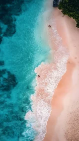 Aerial view of turquoise surf washing onto pastel sand shoreline