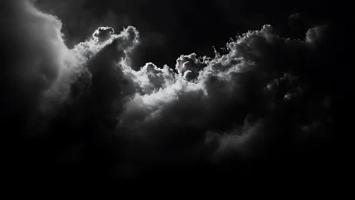 Backlit storm clouds carve glowing edges in darkness.
