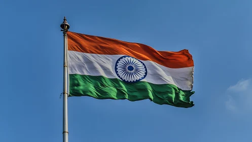 Indian tricolor flag captured mid-wave against clear sky backdrop