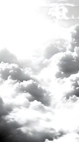 Sunlit cumulus clouds dissolve into bright white sky