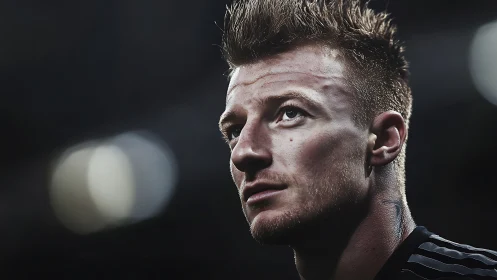 Close-up portrait of focused male football player at night.