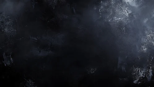 Dark textured surface with subtle tonal variations.