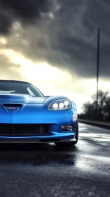 Blue sports car occupies wet roadway under overcast sky