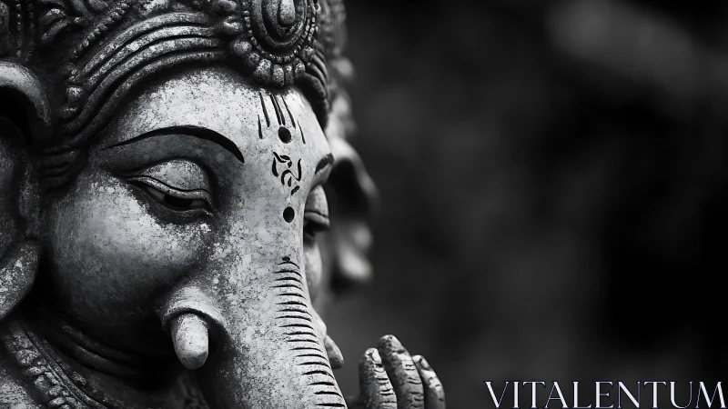 Monochrome close-up of weathered Ganesha stone sculpture.