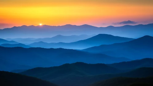 Layered blue mountain ridges under a minimal sunrise sky.
