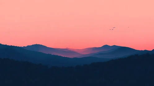 Layered mountain silhouettes recede beneath uniform pink sky