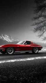 Red classic sports coupe contrasts with snowy mountain road