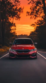 Red BMW sedan dominates empty road under vivid sunset sky