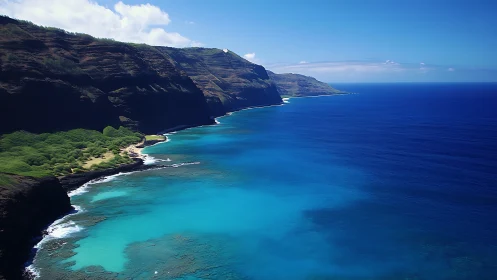 Coastal escarpment with stratified cliffs and cyan littoral waters.