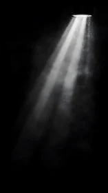 Single overhead spotlight beam through haze in dark void