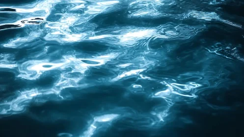 Rippling blue water surface with bright light reflections.