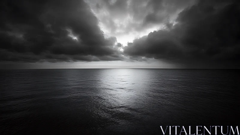 Dark storm clouds over calm monochrome ocean horizon.
