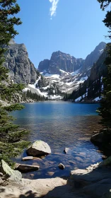Mountain lake with snowcapped peaks and clear blue water.