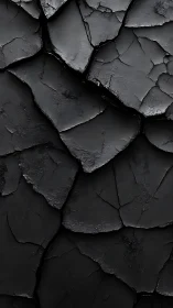Macro study of cracked matte black surface with layered plates