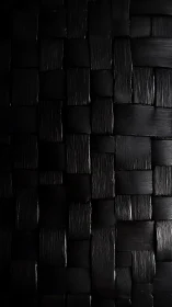 Textured black woven surface with directional side lighting.