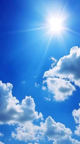 Bright midday sun and playful clouds in wide blue sky.